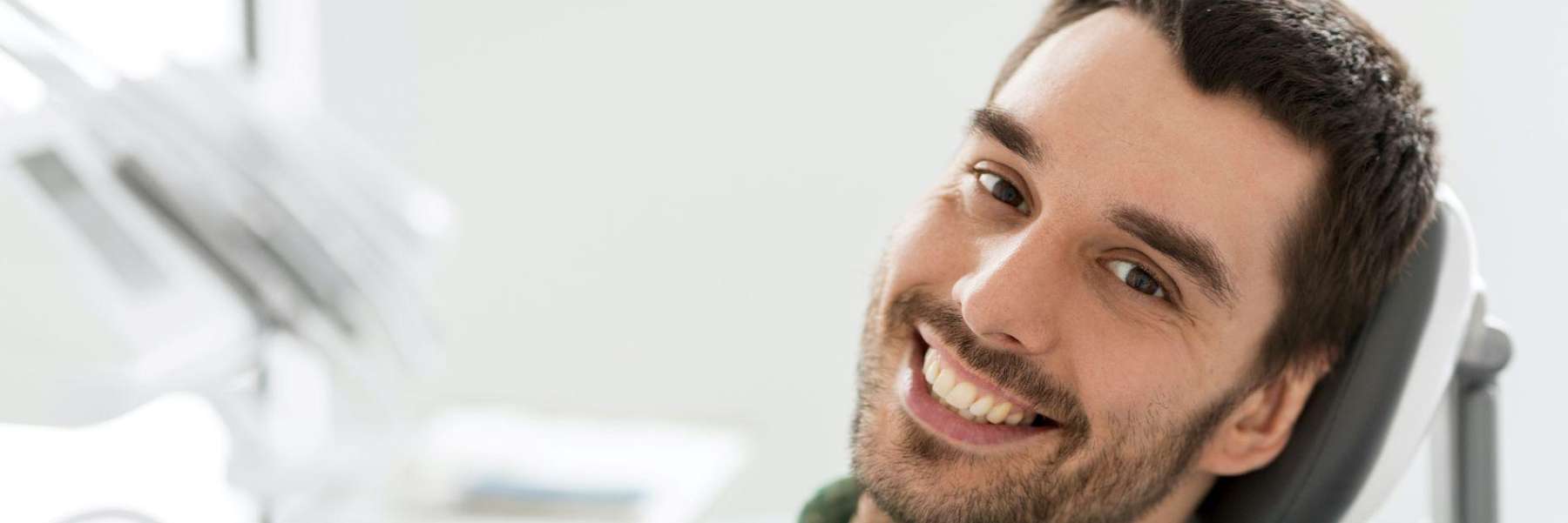 A man smiles in the dental chair, feeling relaxed and positive during his cleaning appointment.