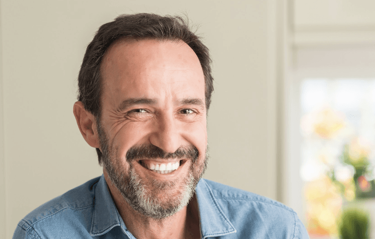 A man smiling confidently, representing dental treatment results.