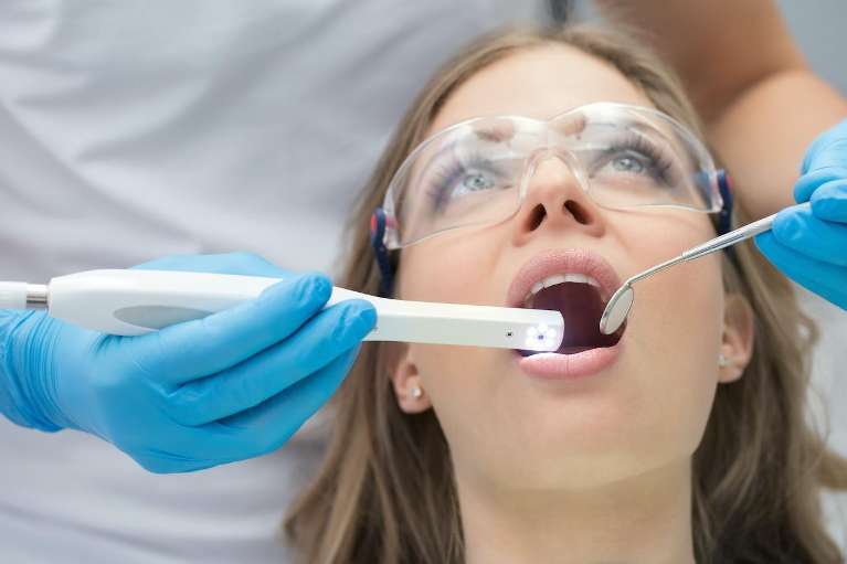A woman receiving a dental cleaning, highlighting post-extraction oral hygiene.