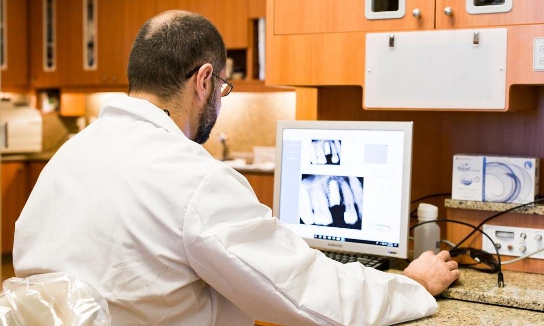 dr. albik looking at dental implant x-ray at el dorado family dental